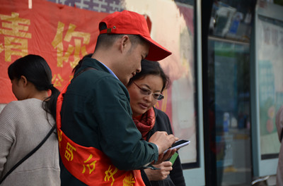 志愿者用手机为市民指引站点_副本.jpg